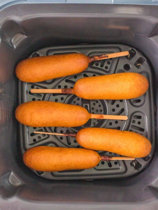 air fryer corn dogs lined up in the basket