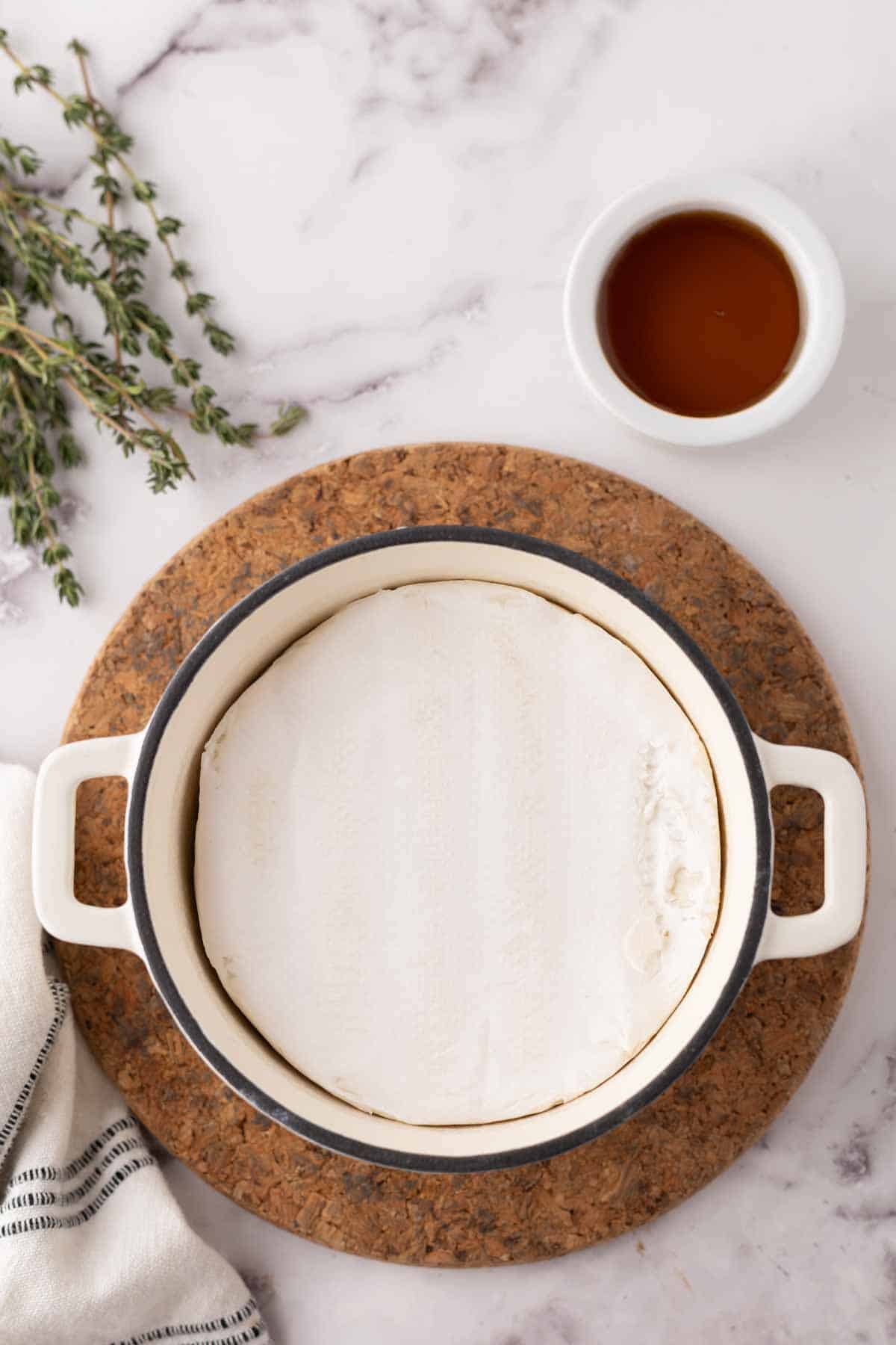 baked brie wheel in a dutch pot with thyme and honey.