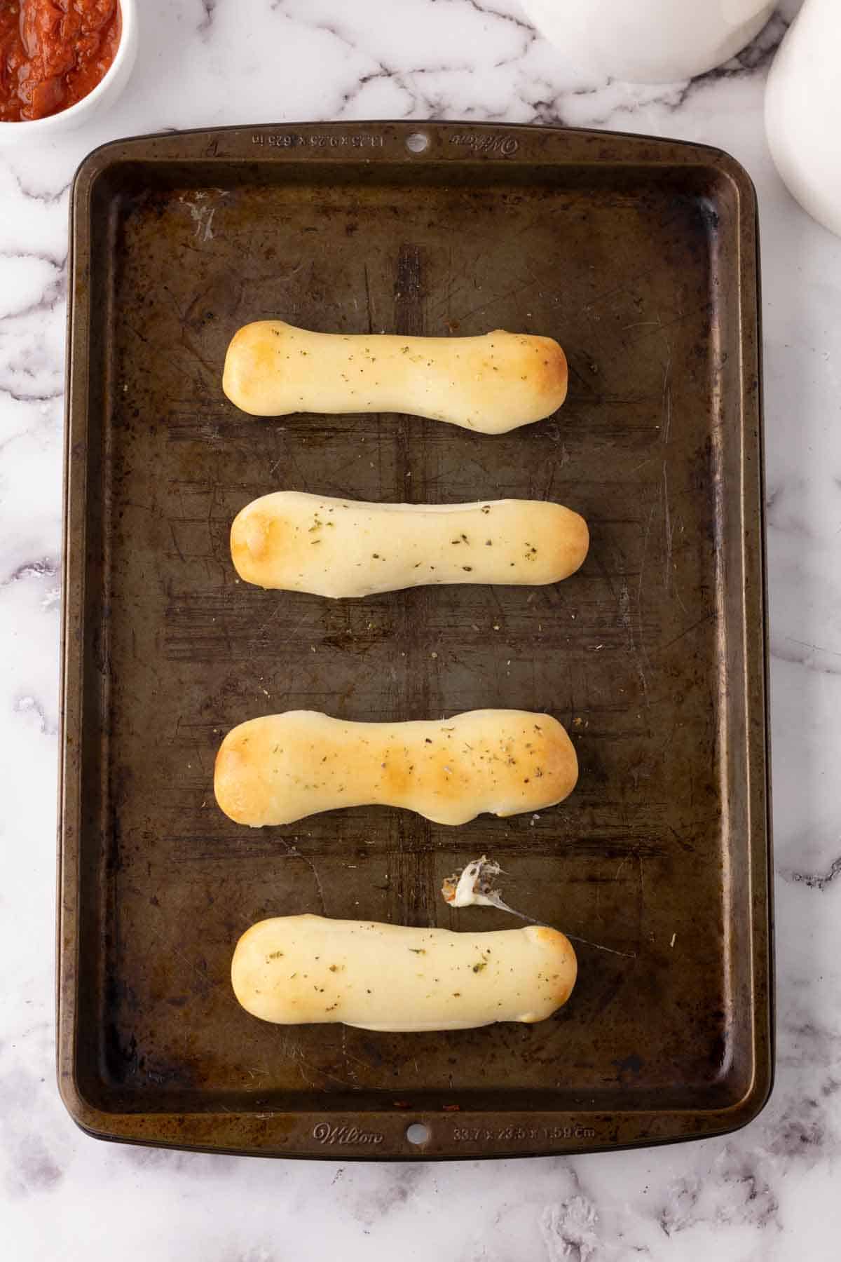 four bosco sticks on a cookie sheet.