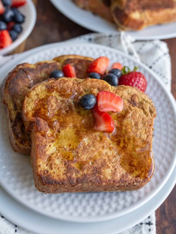 syrup over thick sliced brioche french toast with berries on top