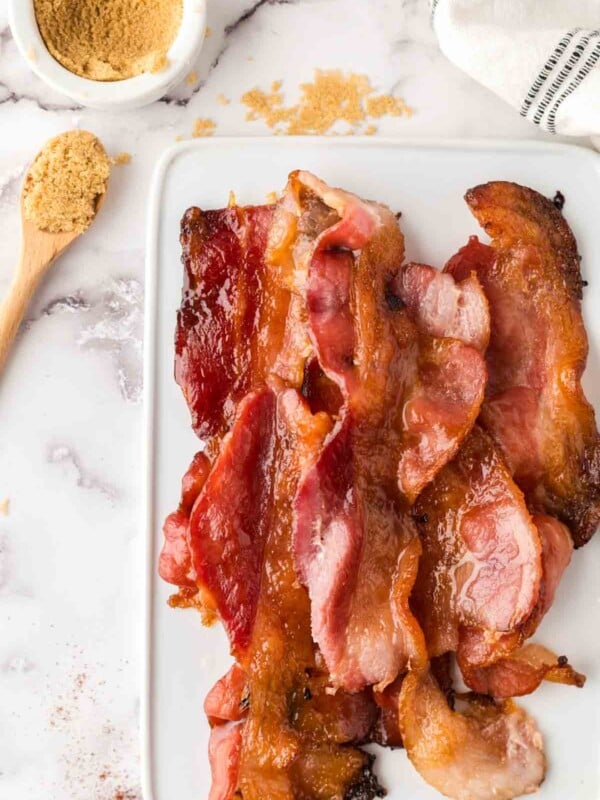 stack of candied bacon on a white tray