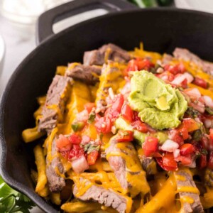 cast iron pan showing the progress of making carne asada fries recipe.