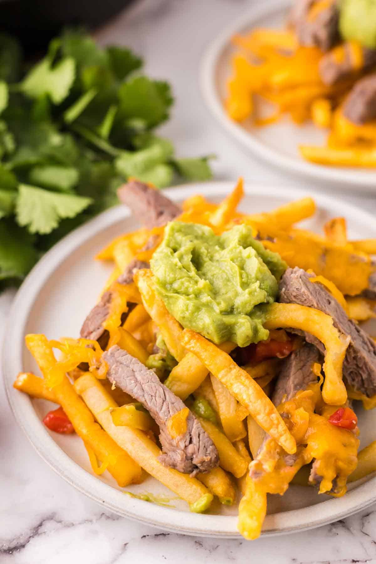 carne asada fries on round white plates.