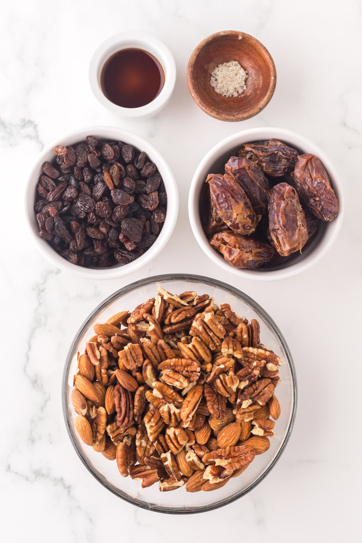 portion bowls each with raw ingredients to make cherry energy balls.