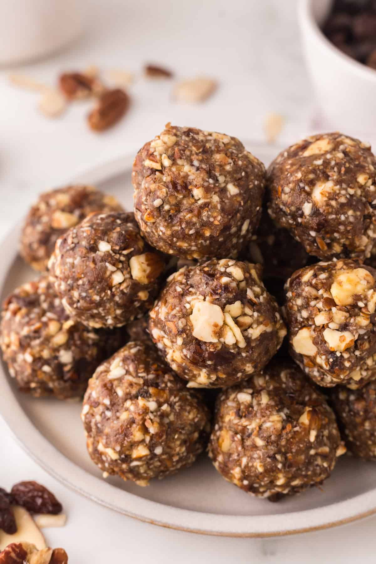 cherry energy balls in a pile on a white plate.