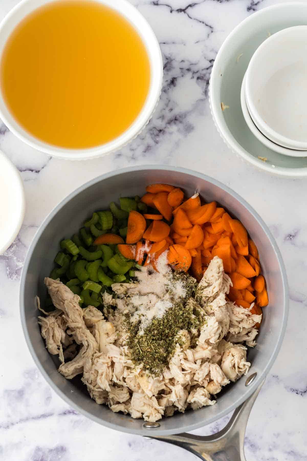 veggies and chicken in a sauce pan for creamy chicken noodle soup