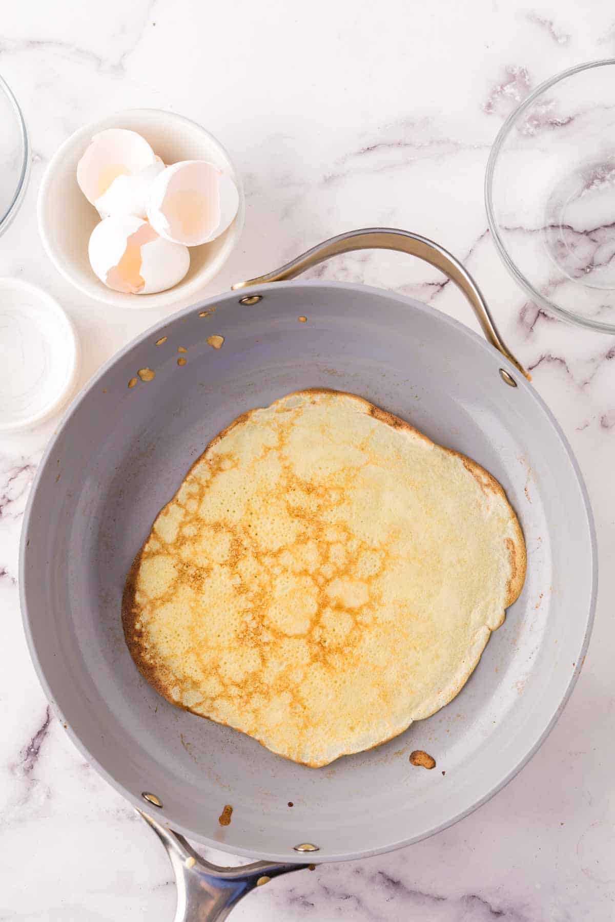 pan in process of cooking the crepe batter.