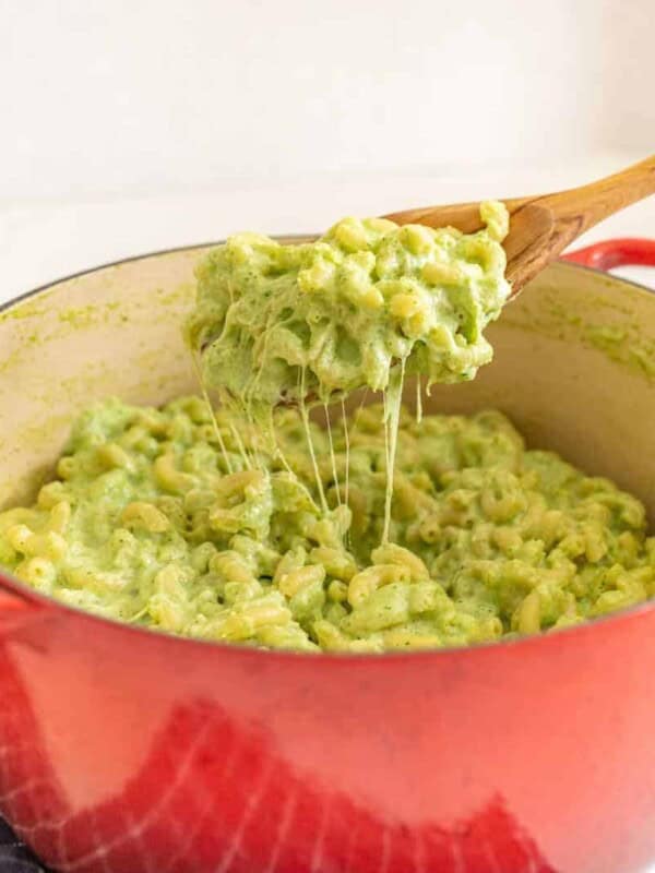 green mac and cheese in a red dutch oven