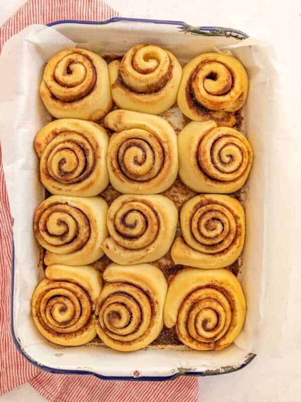 baked cinnamon rolls lined into a pan uniced