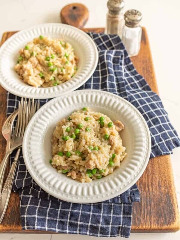 instant pot chicken and rice in white bowls on blue and white towel on cutting board with silverware