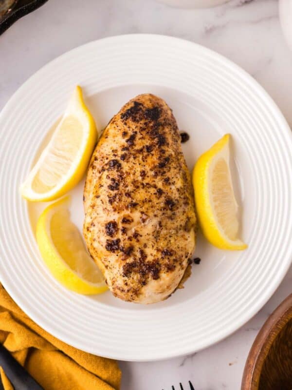 lemon peppered chicken on a round white plate.