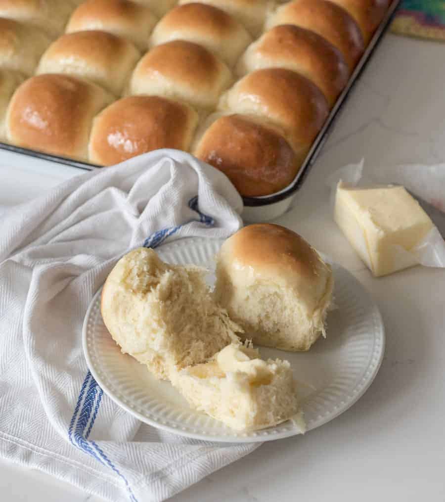 open dinner roll on plate with fresh butter in the middle melting. 