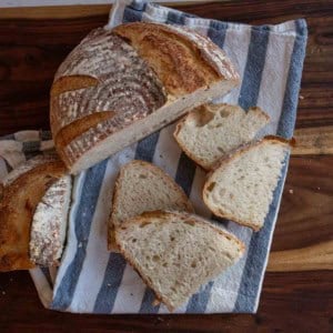 sourdough loaf cut into halves with some slices.