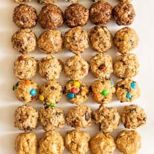 all 8 kinds of oatmeal energy bites all lined up in a 5 by 8 pattern on a white board