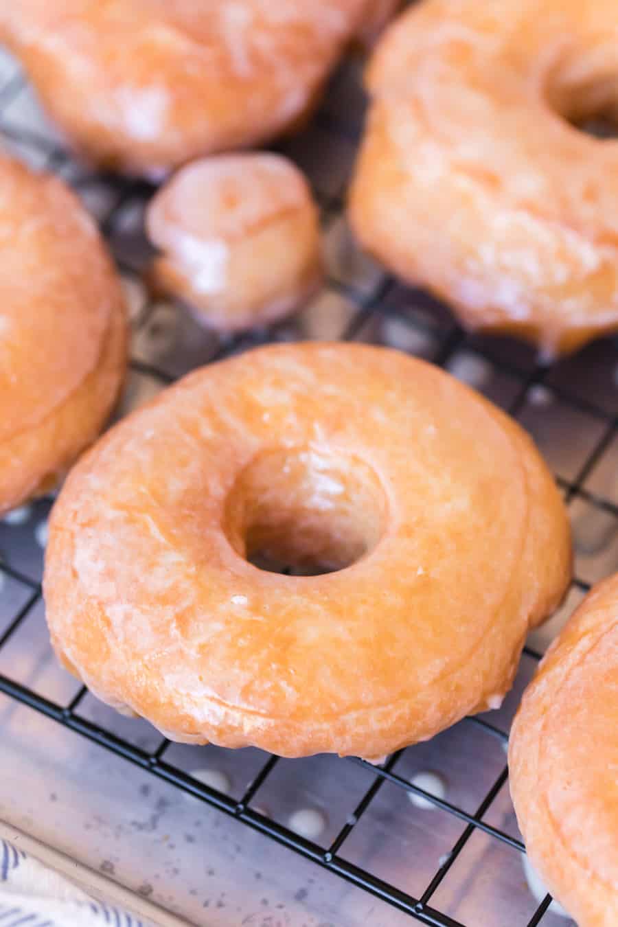 Glazed donuts on a rack.