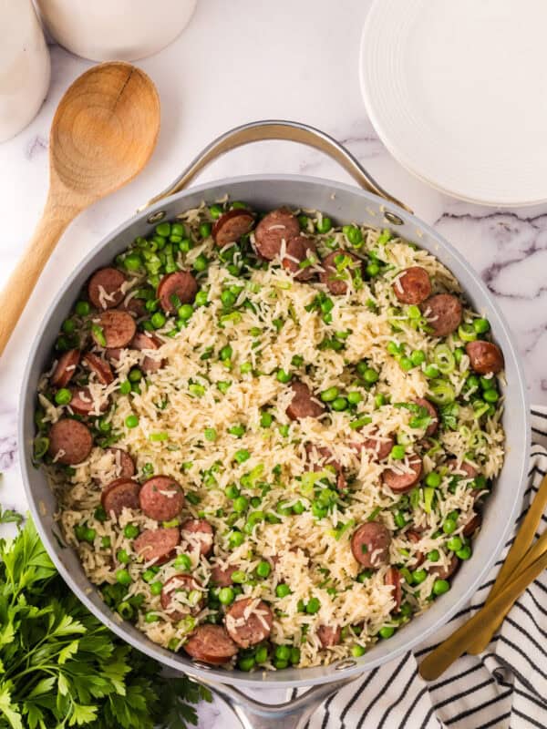 one pot sausage peas and rice in a pan in the progress of cooking.