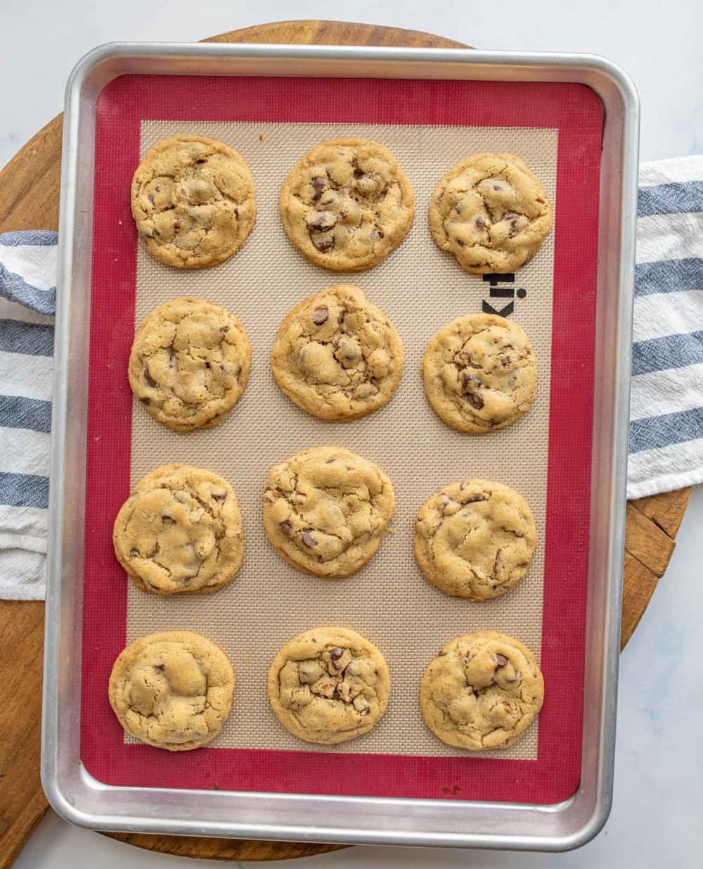 top view of rows of chocolate chip cookies complete on a baking dish.