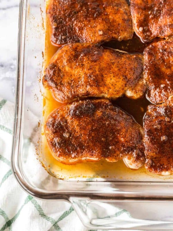 clear baking dish with seasoned pork chops in a sauce