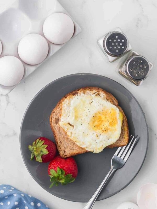 wheat toast with an over hard egg on top served on a grey plate