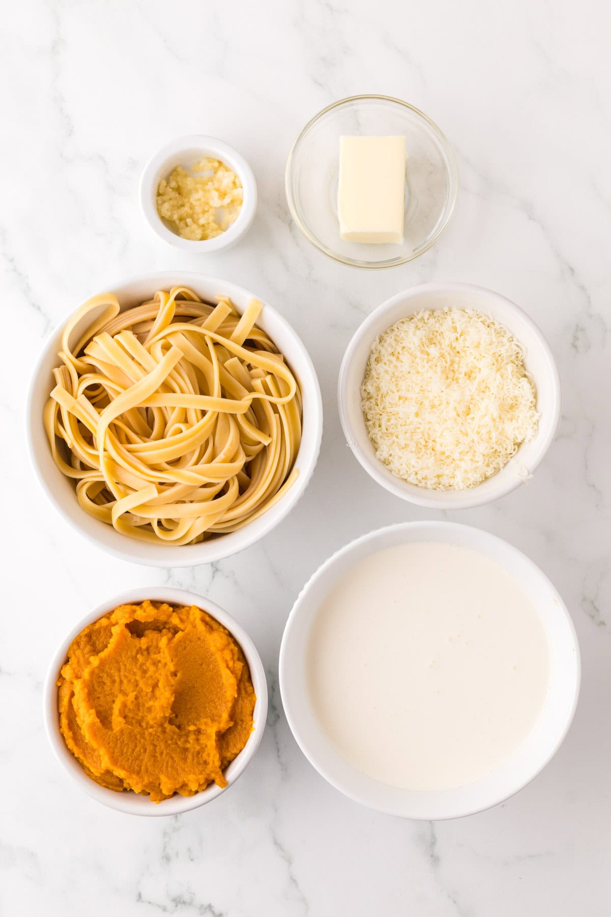 portion bowls each with raw ingredients to make pumpkin Alfredo recipe.