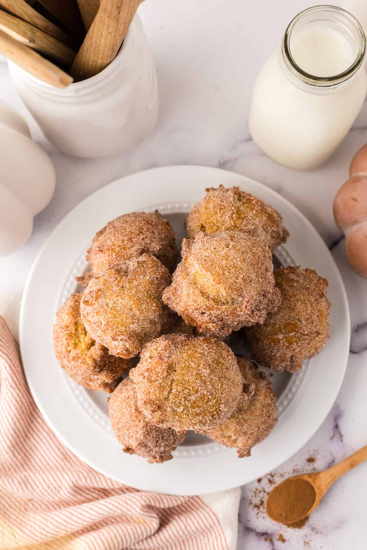 pumpkin donut holes in a pile on a white plate.