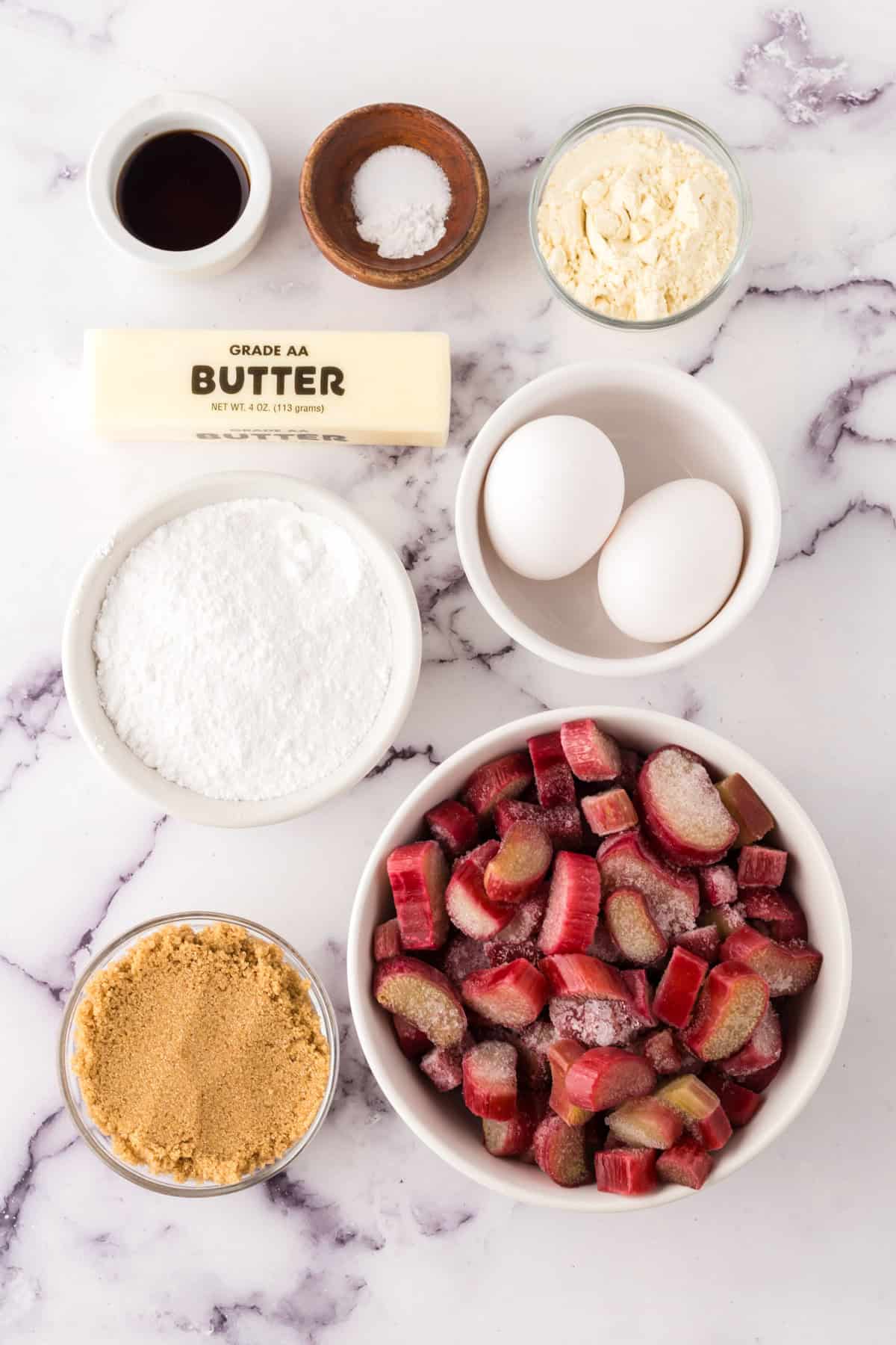 portion bowls each with raw ingredients to make rhubarb crumb bars.