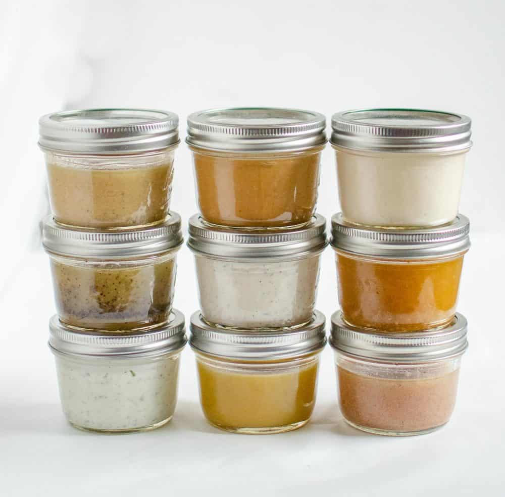 Jars of different salad dressings stacked on top of each other.