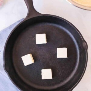 cast iron skilled cold, with 4 pads of butter ready to begin melting