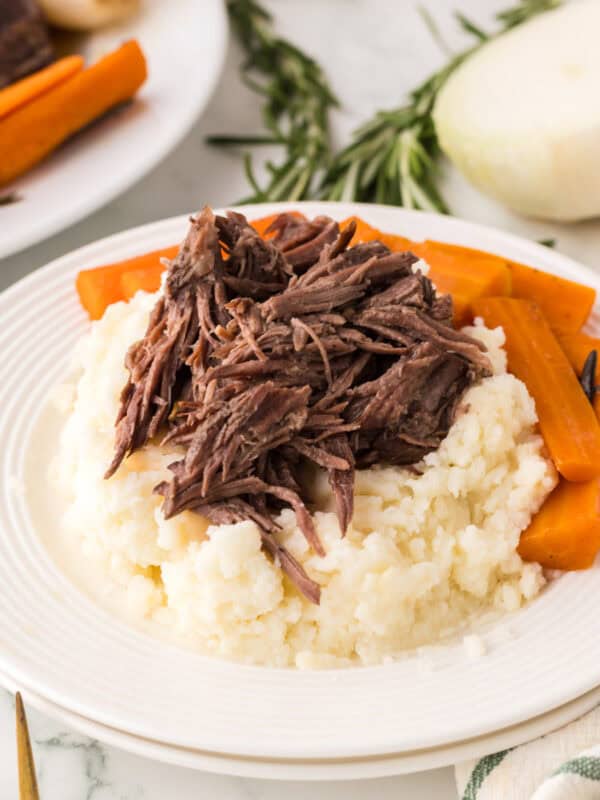 slow cooker pot roast dinner on a round white plate.