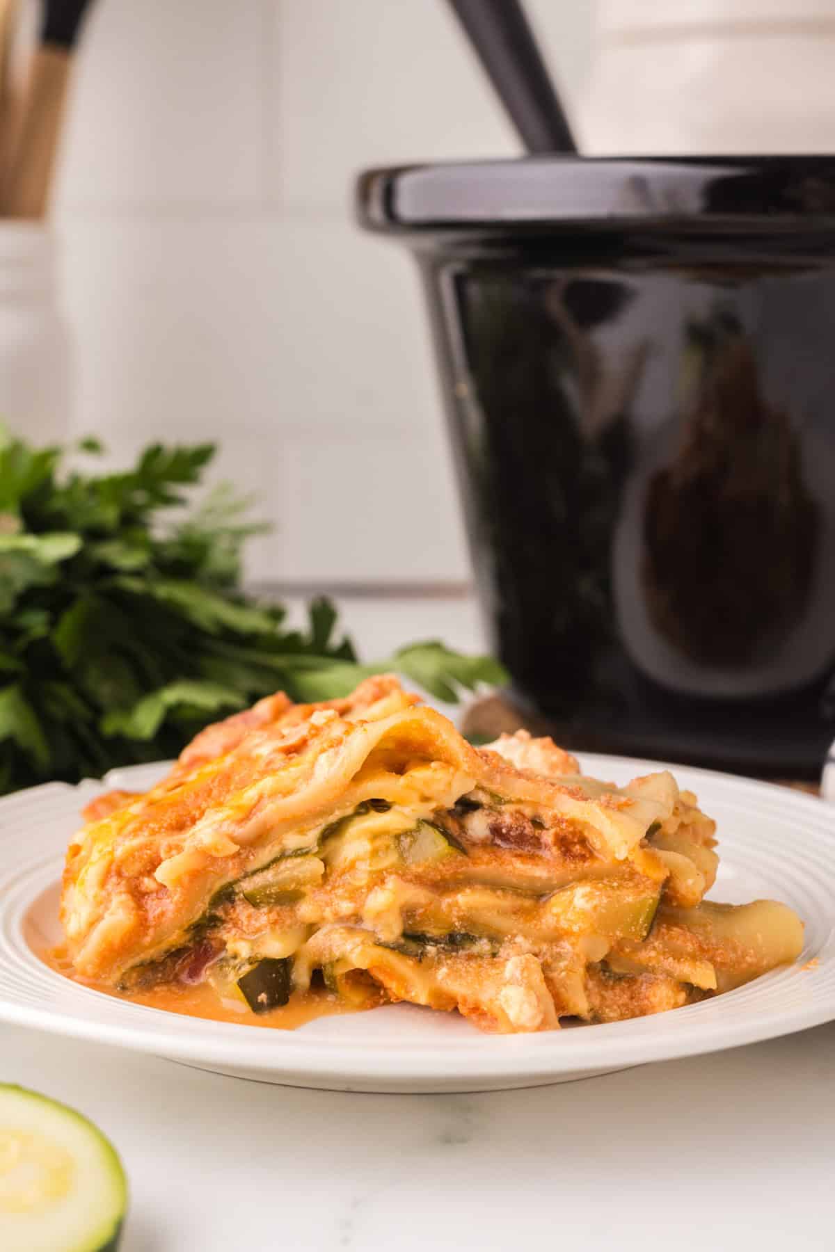 slow cooker veggie lasagna recipe served on a round white plate.