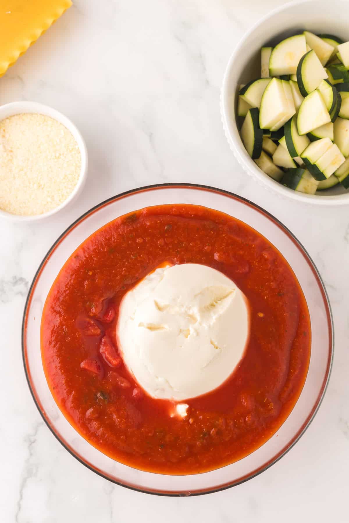 clear glass bowl with ingredients to make slow cooker veggie lasagna sauce.