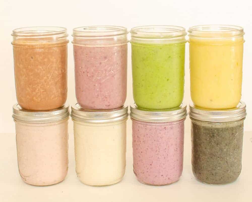 Glass jars filled with smoothies stacked on top of each other.