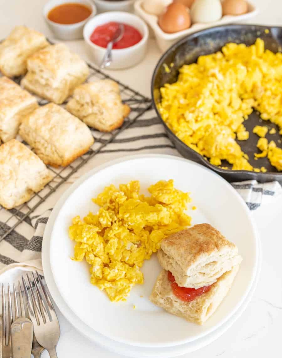 sourdough biscuits in a breakfast photo with scrambled eggs and jam.