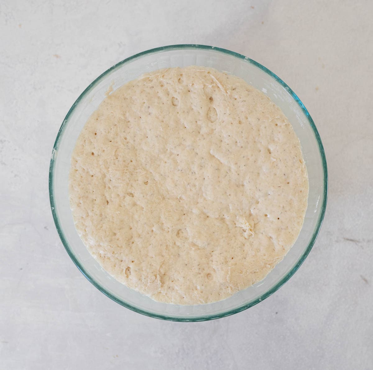 puffed up sourdough english muffin ingredients in glass bowl.