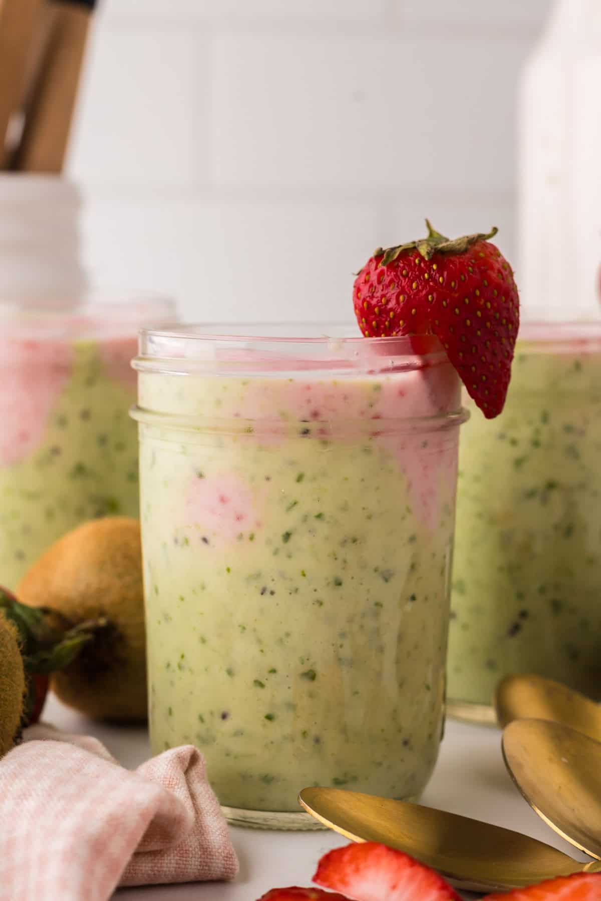 mason jar with strawberry kiwi smoothies inside.