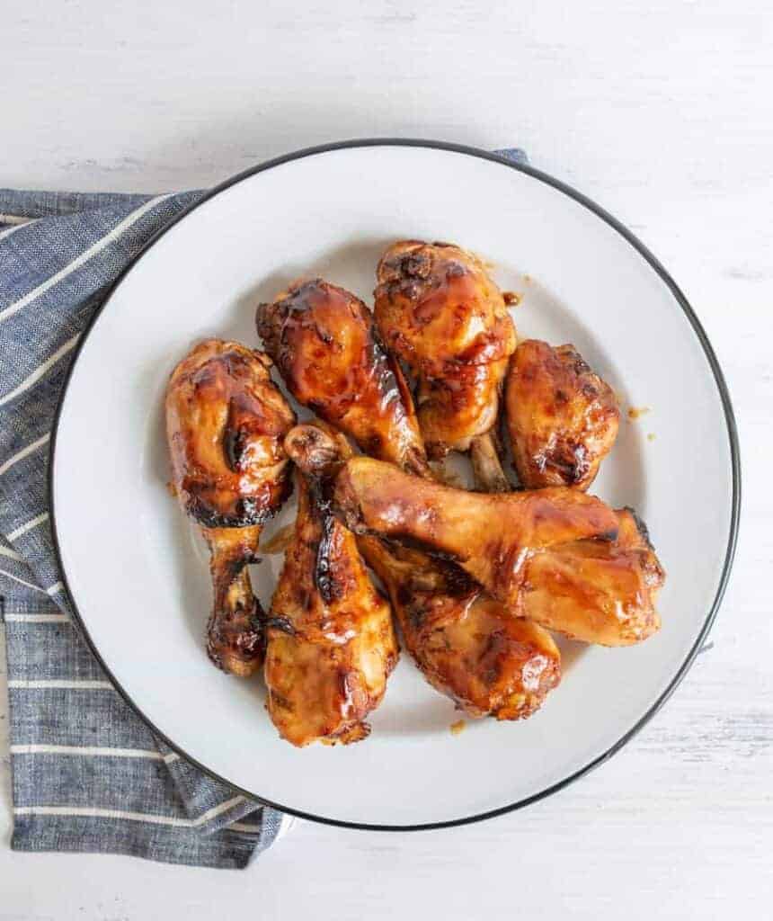 top view of sticky saucy chicken drumettes on a white plate