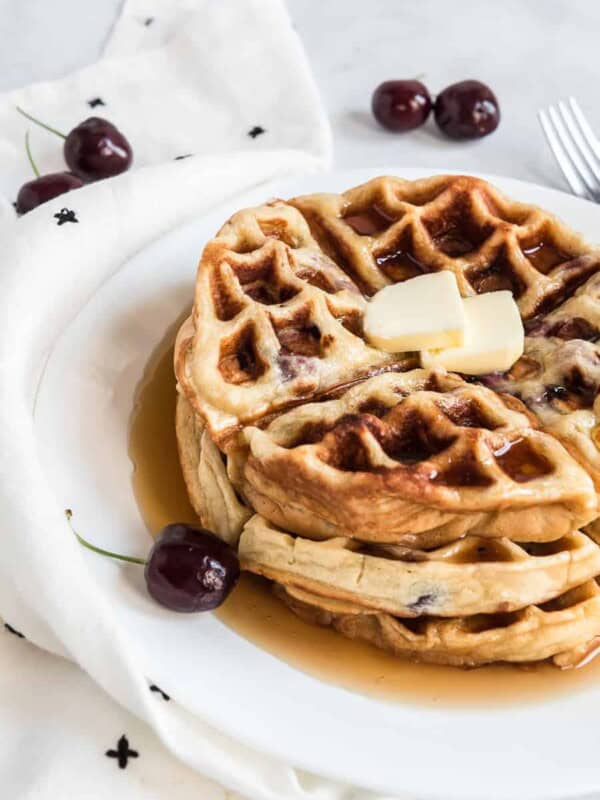 sweet cherry waffles with butter on top on a white plate