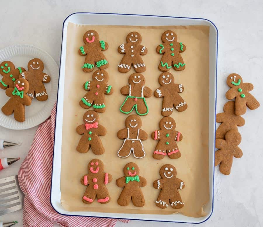 top view of traditionally decorated holiday ginger-people cookies on a sheet pan