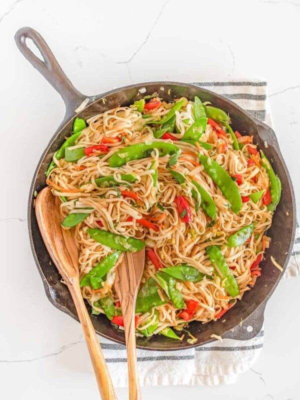 veggie lo mein in bowls served from the cast iron pan